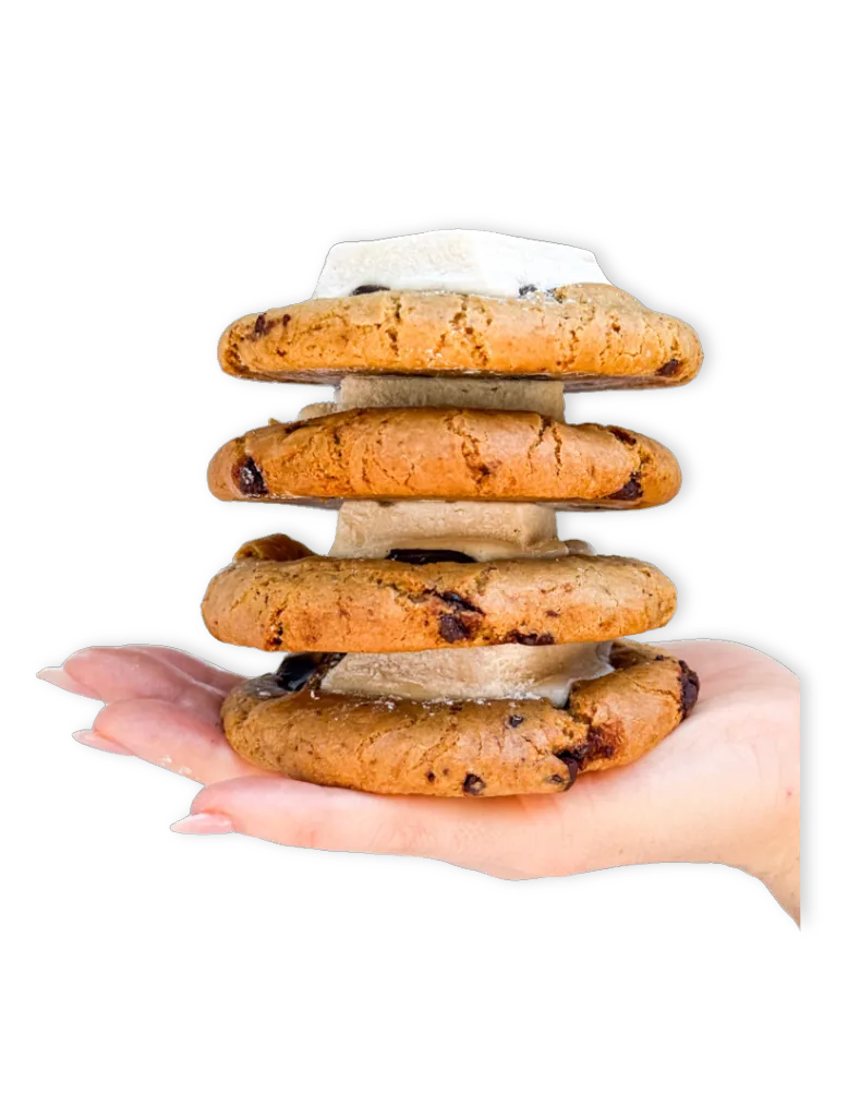 A hand holding a stack of Nowhere chocolate chip cookies.